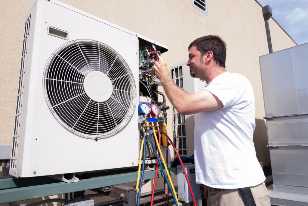 A Pronto technician in a white shirt expertly services an outdoor AC unit, using tools with gauges and hoses attached.