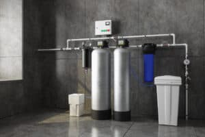 A Pronto Plumbing water filtration and softening system installed on a tiled wall, with metal tanks, filters, and control box.